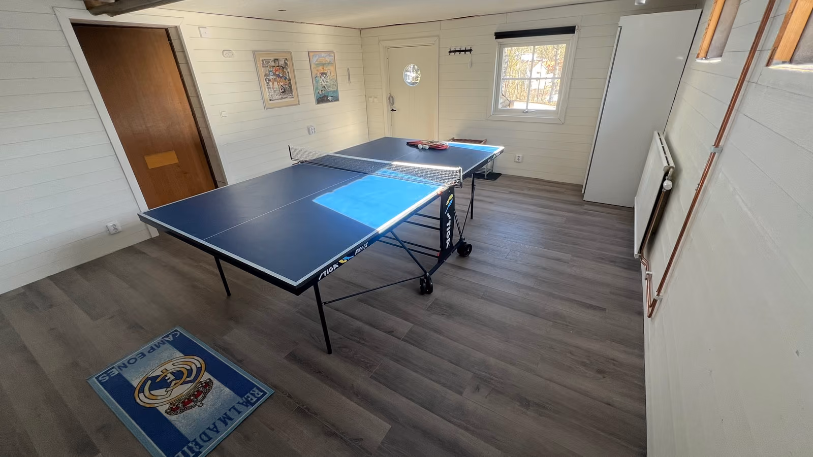 Pingisbord i ett ljust panelat rum med egen ingång